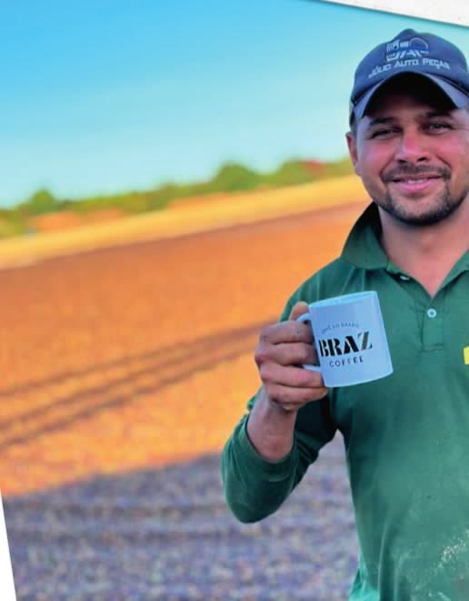 A farm worker holding a Braz mug in a coffee field